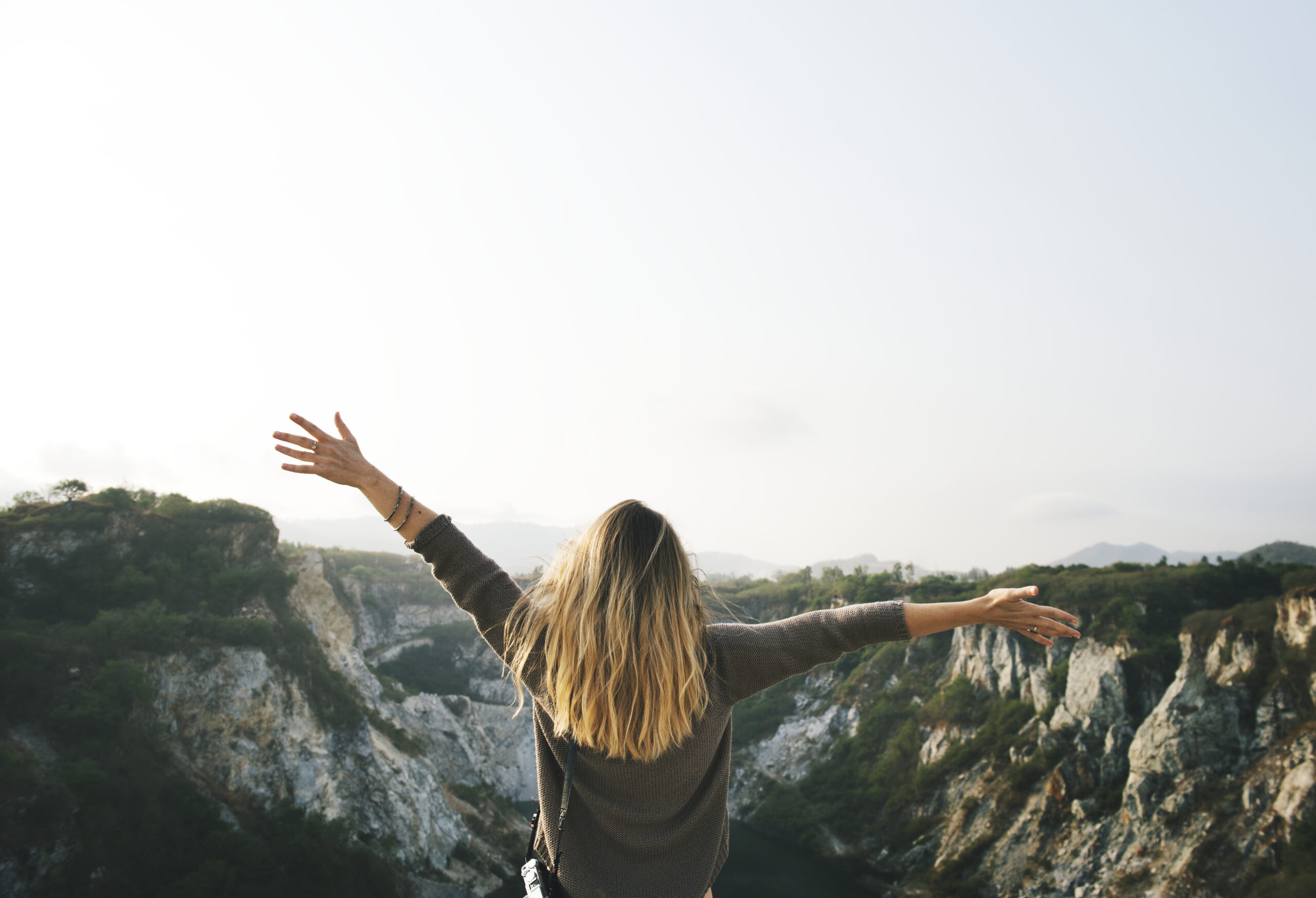 carefree woman arms outstretched on the mountain