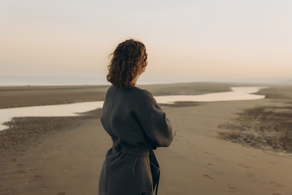 a,woman,in,a,warm,gray,coat,stands,peacefully,on